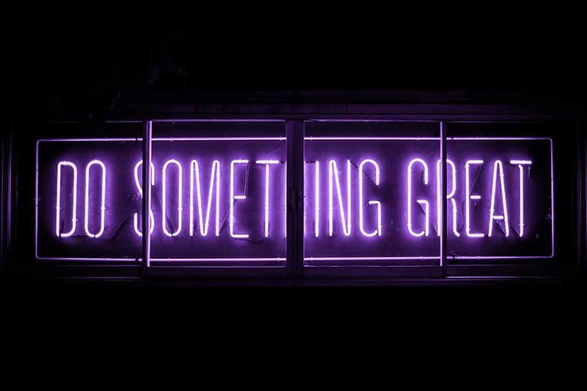 Neon sign that reads "do something great." 